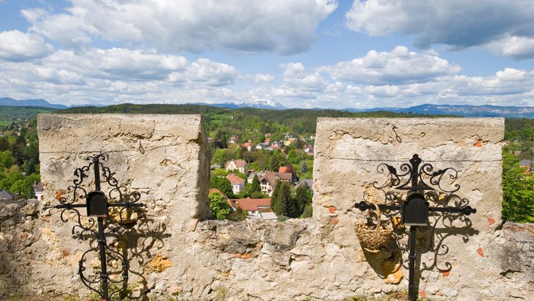 View from an old stone wall of a rural landscape with mountains in the background.