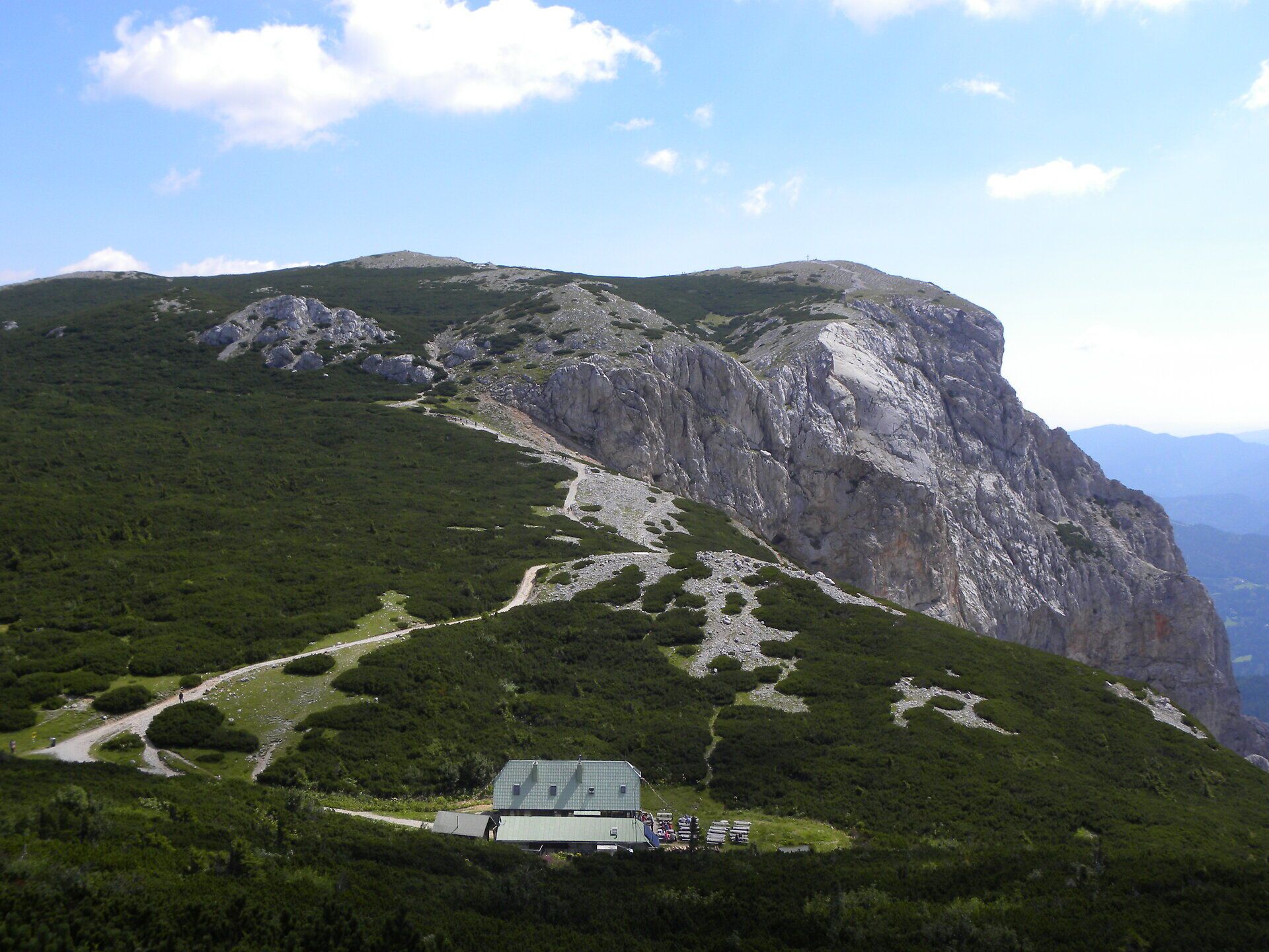 Mountain landscape on the Rax with striking rock formations, hiking trails and a refuge under a blue sky.