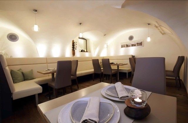 Elegant dining room with vaulted ceiling, modern furniture and table setting.