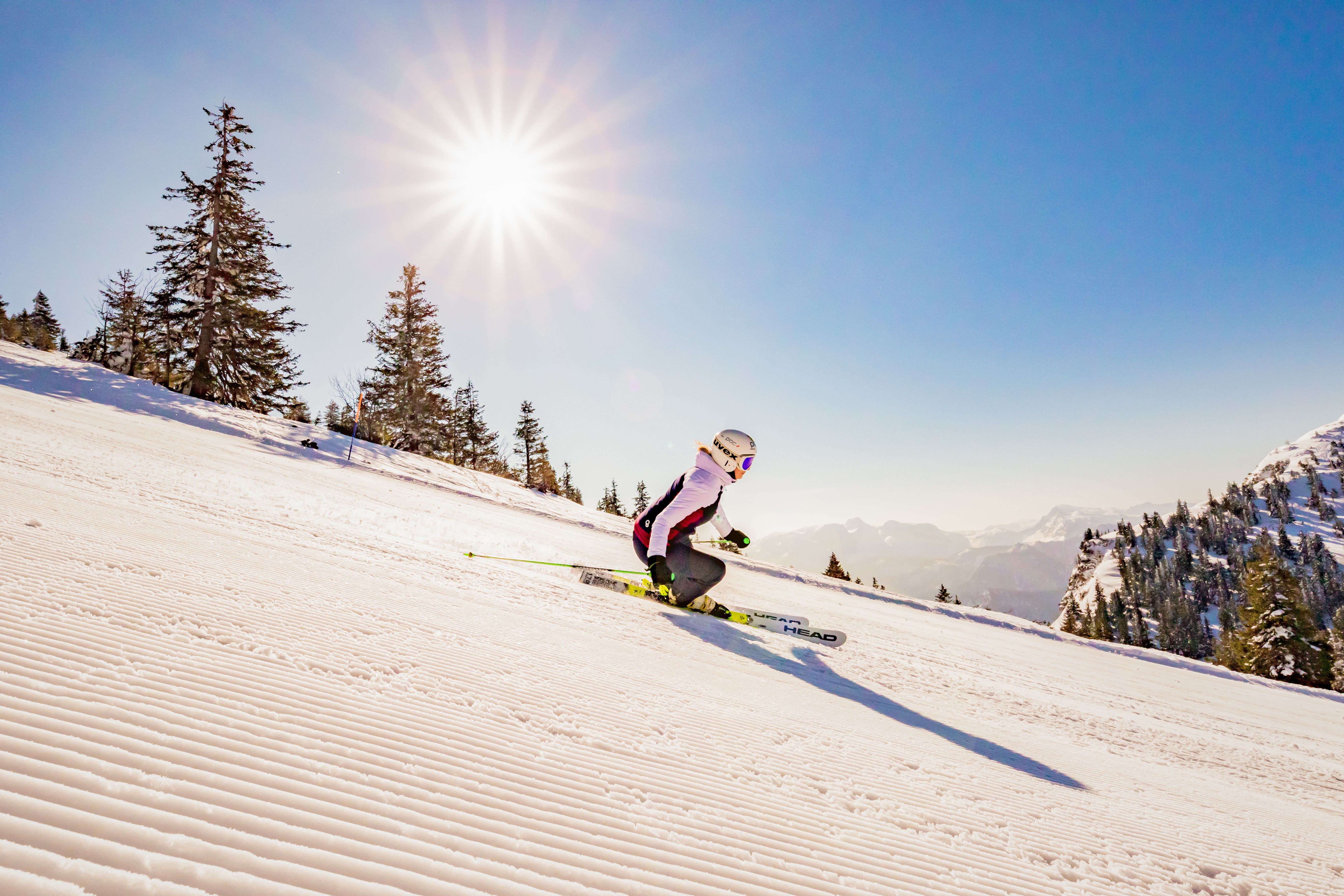 Der glitzernde Schnee reflektiert die ersten Sonnenstrahlen des Tages, während ein Skifahrer elegant die Piste hinuntergleitet. Die frische Bergluft und die ruhige Atmosphäre des Morgens schaffen ein unvergessliches Erlebnis für alle Wintersportliebhaber. Hier, in den majestätischen Alpen, beginnt der Tag mit einem Hauch von Abenteuer und Freiheit.
