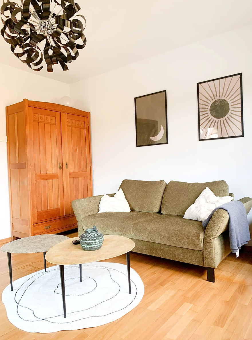 green sofa in room with wooden floor and wardrobe 