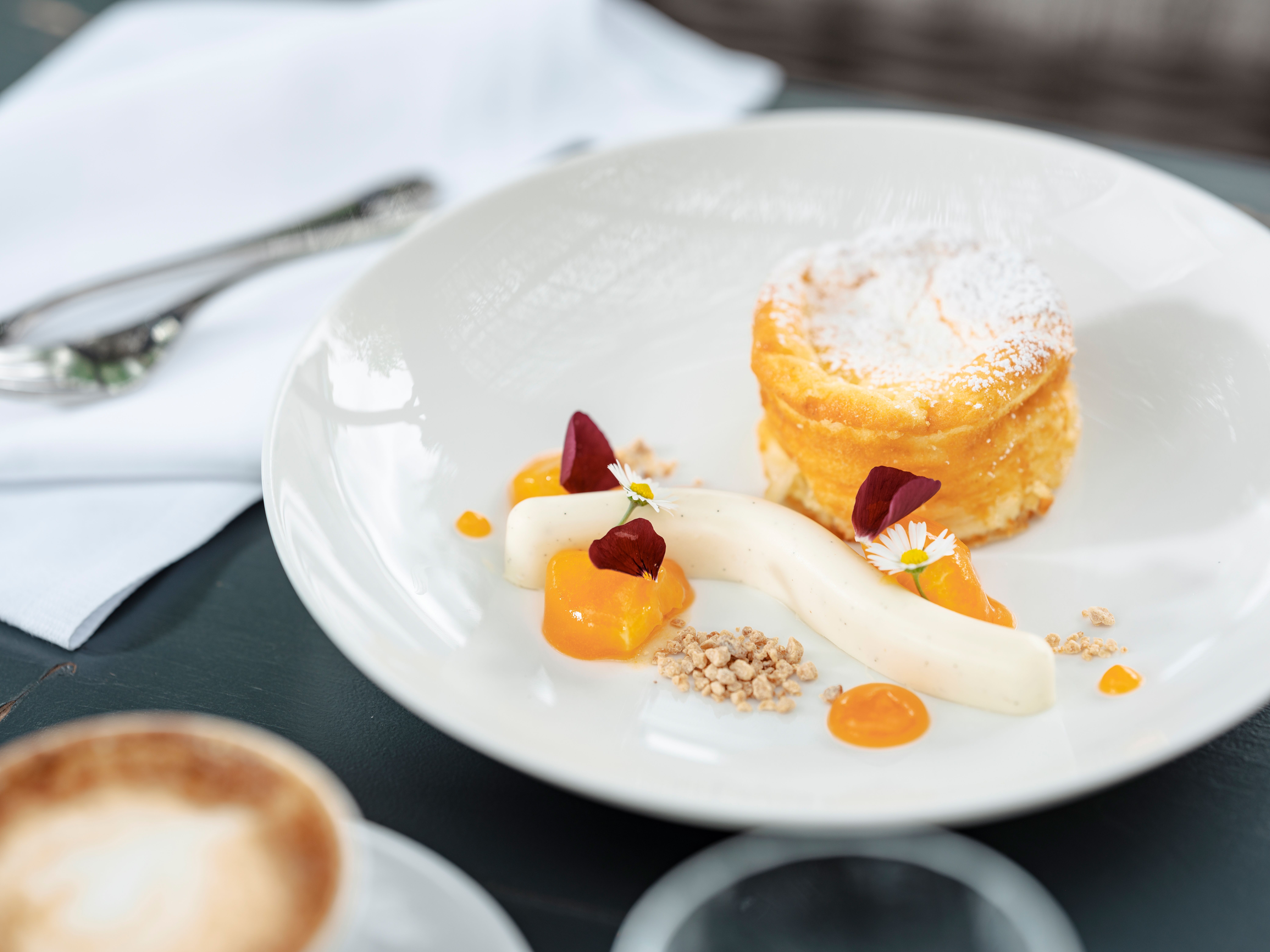 Ein köstliches Dessert aus luftigen Topfensoufflés und fruchtiger Marille verzaubert die Sinne. Die zarte Süße und die frischen Aromen laden dazu ein, einen Moment der Entspannung und des Genusses zu erleben. Perfekt für eine süße Auszeit nach einem erlebnisreichen Tag in der malerischen Umgebung.