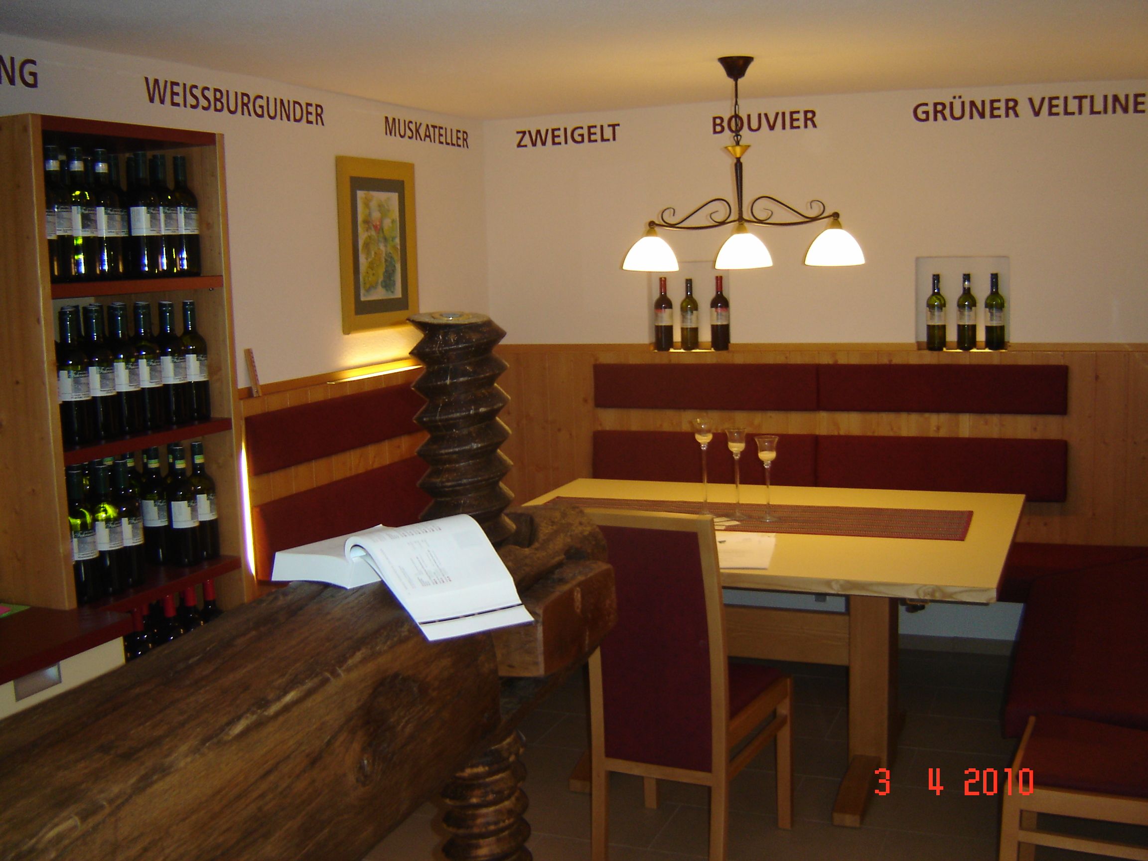 Interior view of a winery with table, chairs and wine racks.