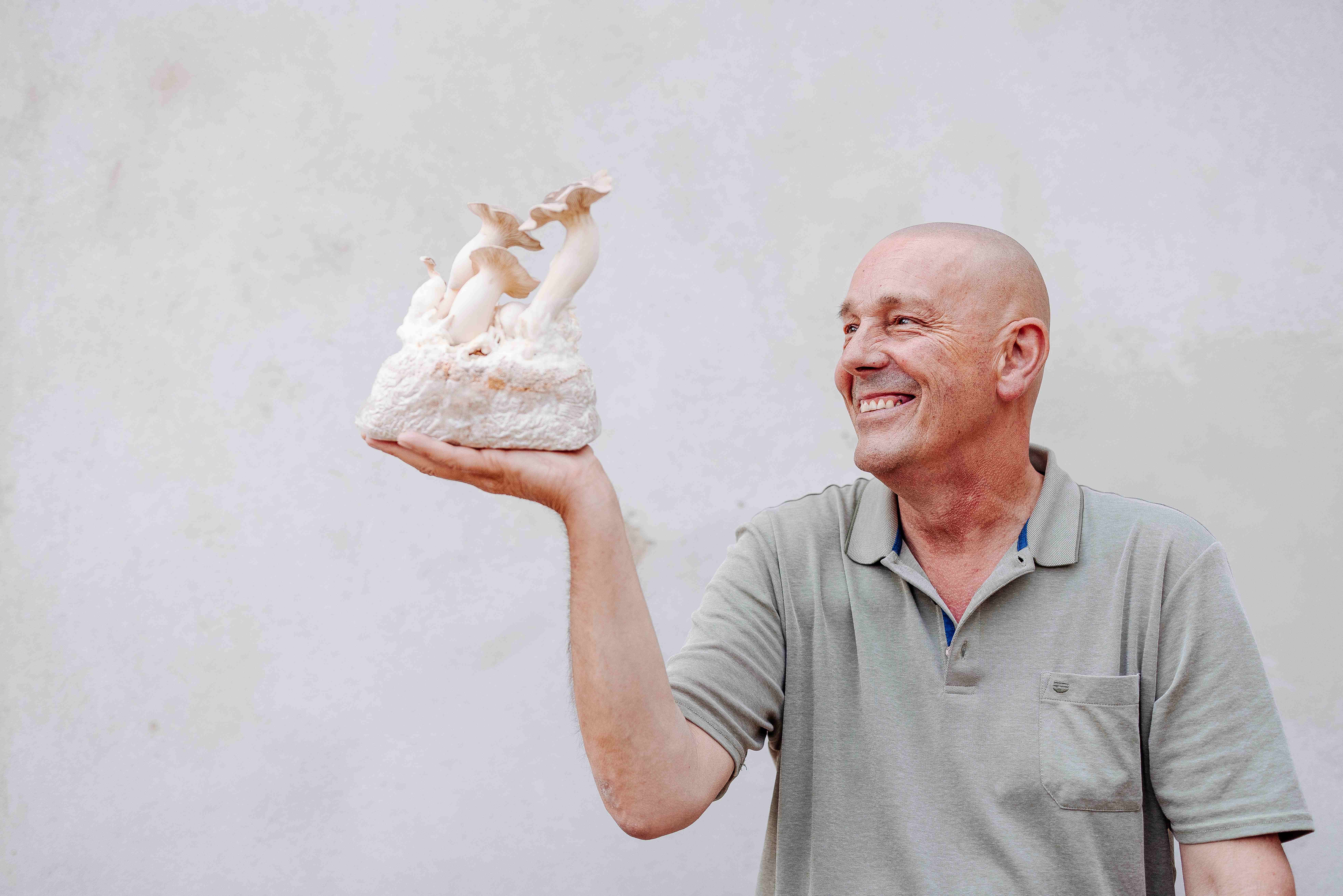 A beaming man proudly holds an exquisite sculpture that reflects the beauty of nature. The soft colors and artistic design invite you to discover the culinary delights of the region. A perfect moment to celebrate the connection between art and pleasure.