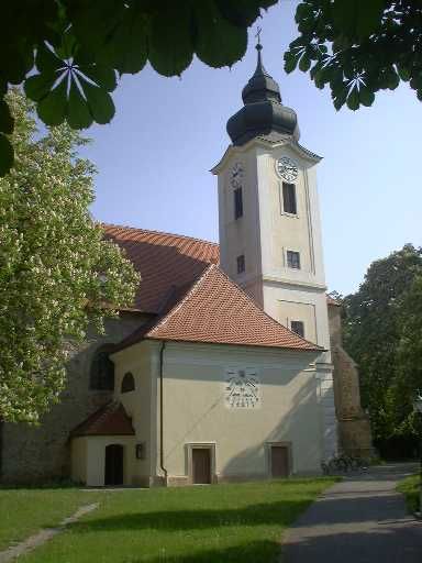 Zwentendorf parish church with tower and clock, surrounded by trees.
