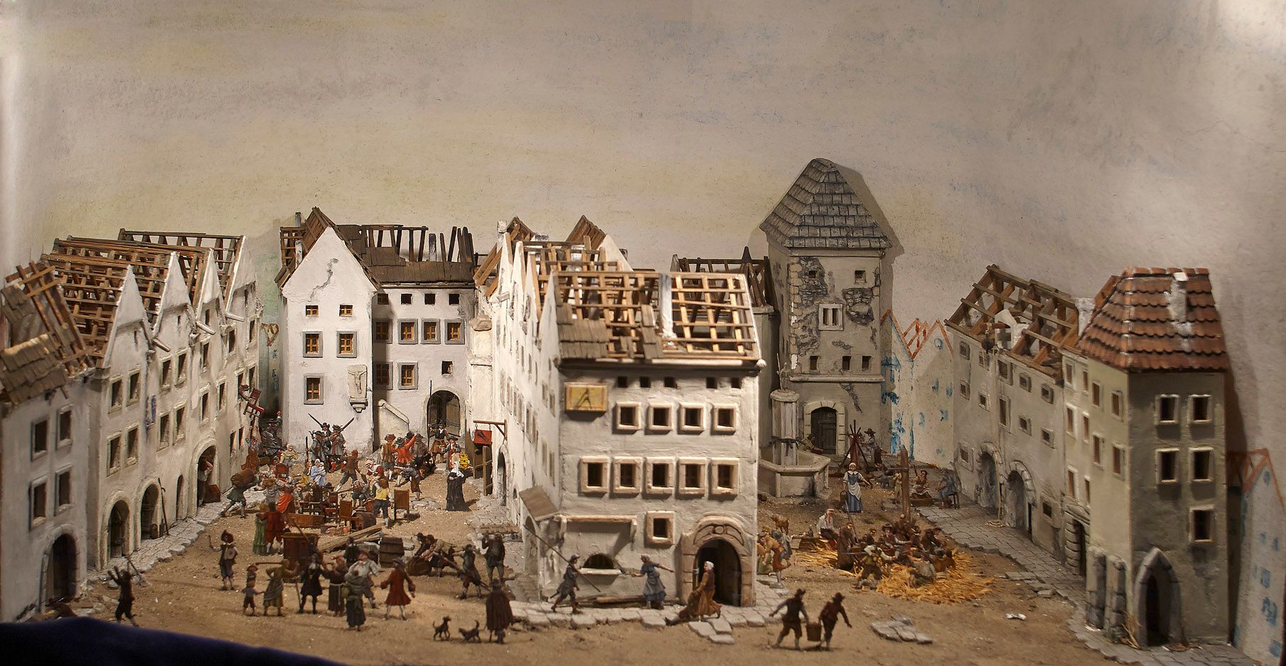 Miniature town with figures in a historical setting.