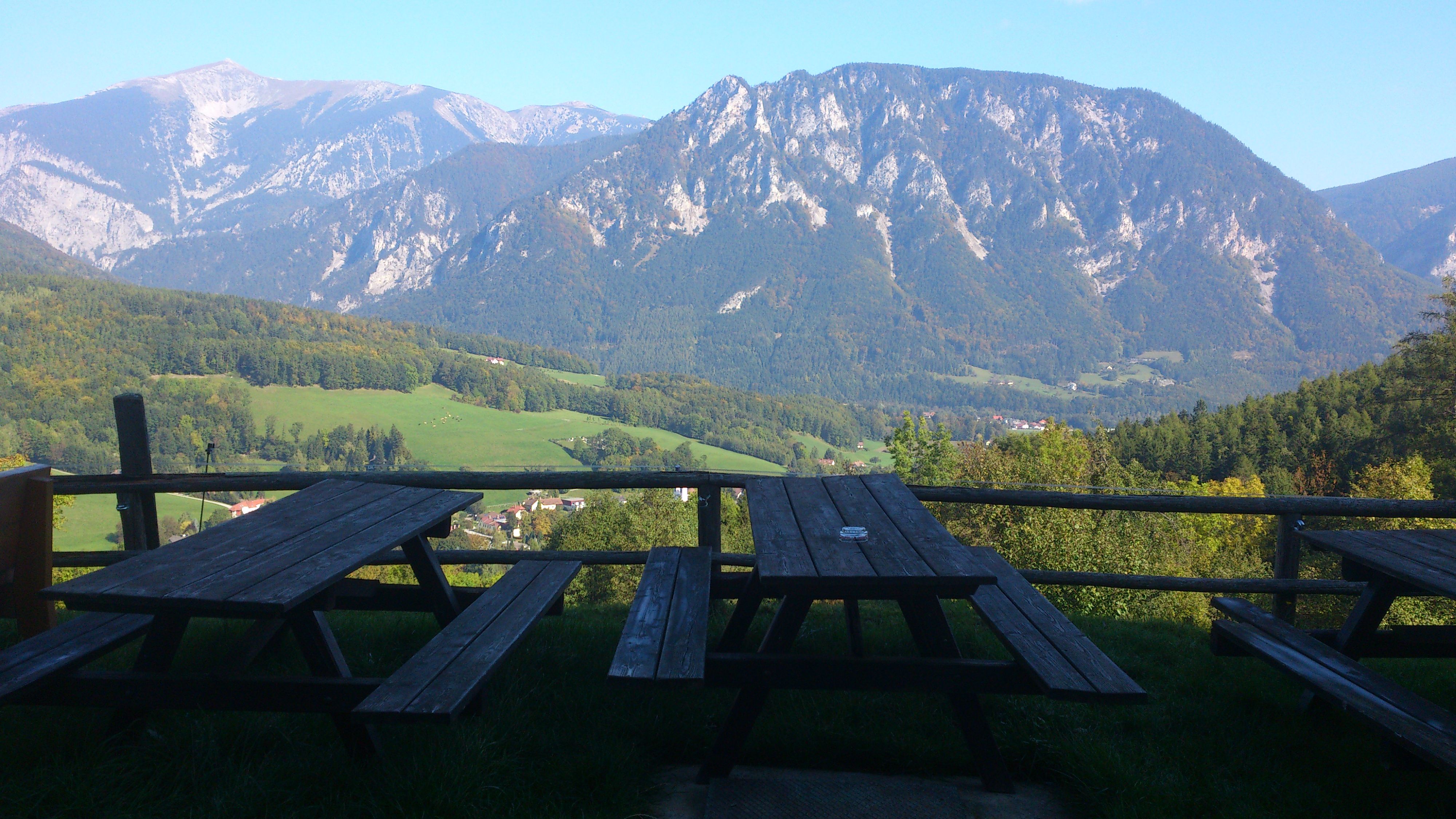 Wooden benches with views of wooded mountains and valleys.