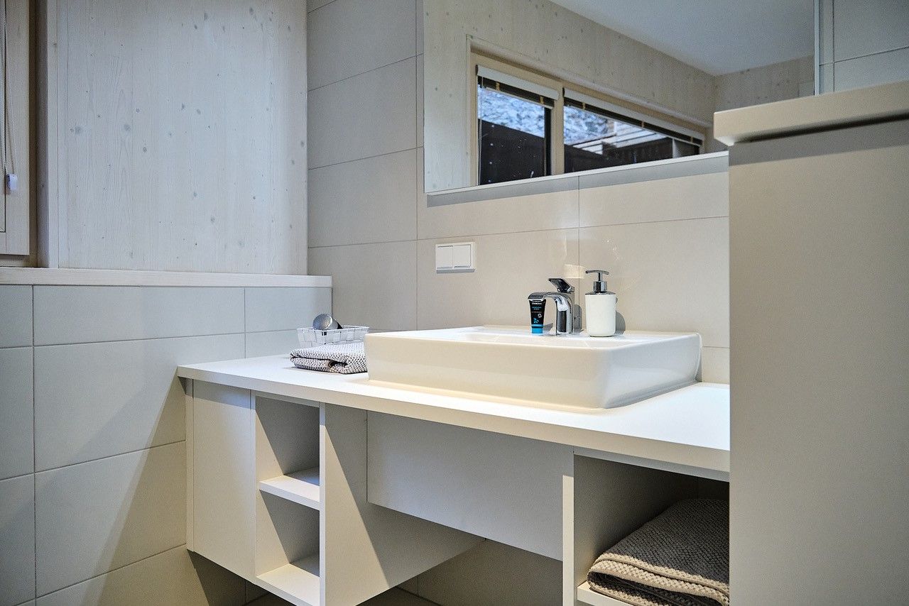 Modern bathroom with white washbasin, mirror and towels.