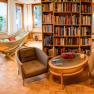 Cozy library with hammocks, armchairs and bookshelves in a hotel.