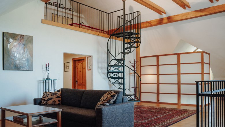 Spiral staircase up to the sleeping area, cozy couch in the foreground