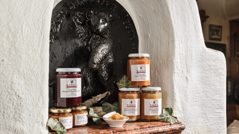 Various jam jars in front of a bear relief