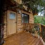 Terrace of a wooden tree house with entrance door
