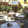 Outdoor area of the DONAUWIRT Hotel with laid tables and plants.
