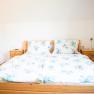 Doppelzimmer mit blumiger Bettwäsche