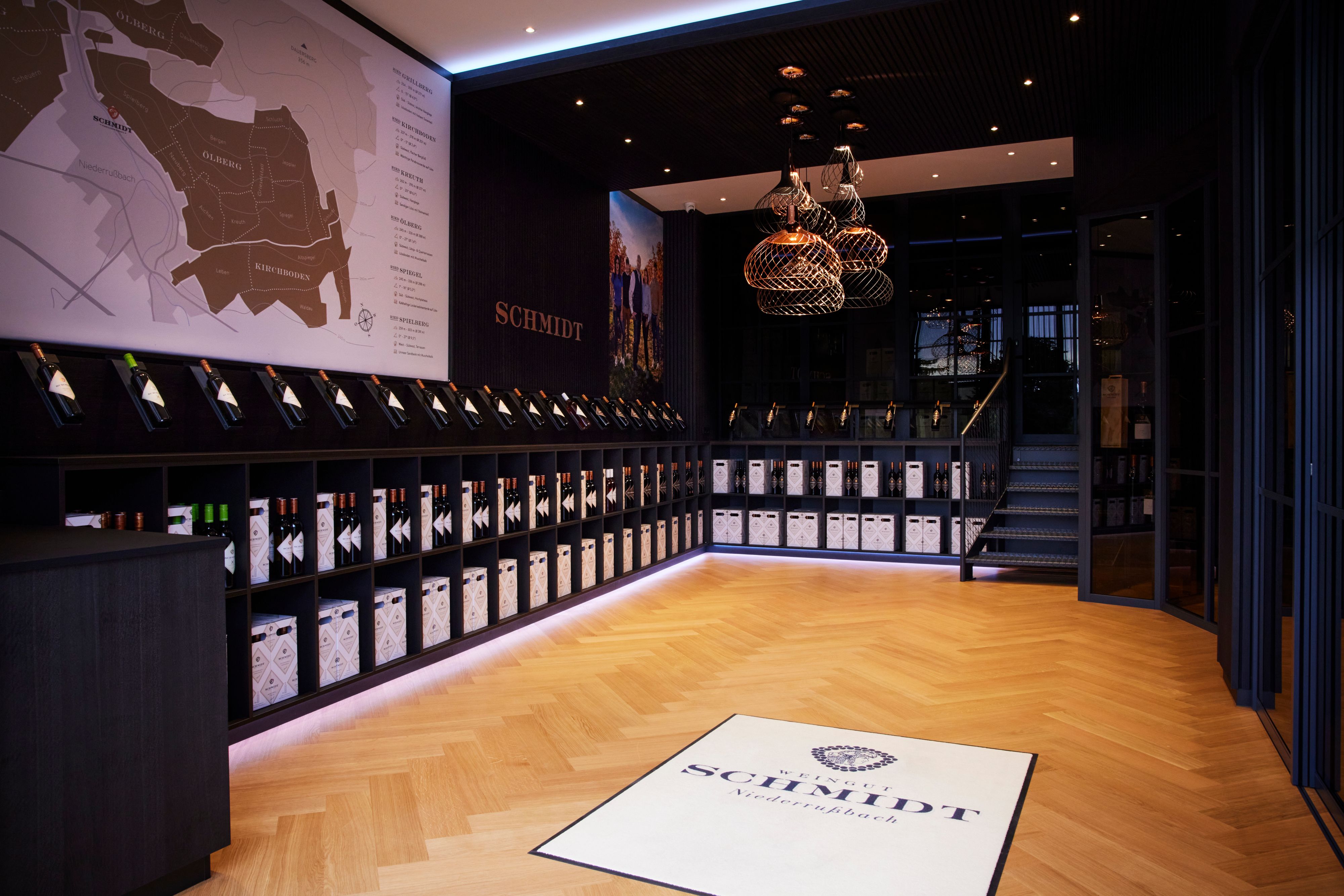 Interior view of a modern wine store with wooden floor, wine bottles on shelves and a large wall map.