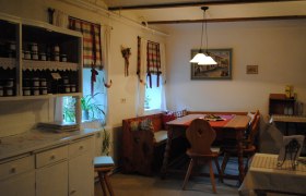 Cozy kitchen with wooden furniture and checkered curtains.