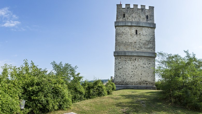 Fire tower of the Kirchschlag castle ruins with picnic table in the foreground.