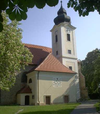 Zwentendorf parish church with tower and clock, surrounded by trees.