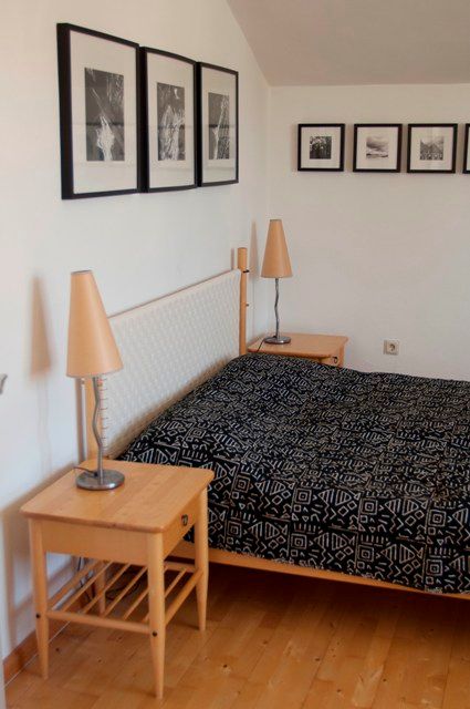 Bedroom with double bed, bedside tables and wall pictures.