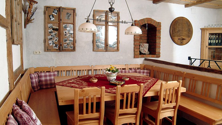 Cozy tasting room with wooden furniture, tablecloth and decorations on the walls.