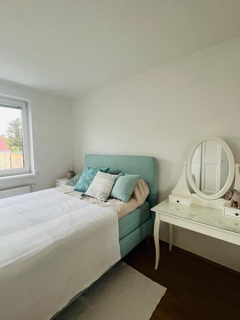 Bedroom with a bed, pillows and a dressing table with mirror.