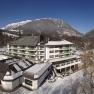 Parkhotel Hirschwang in winter with snow-covered mountains in the background.