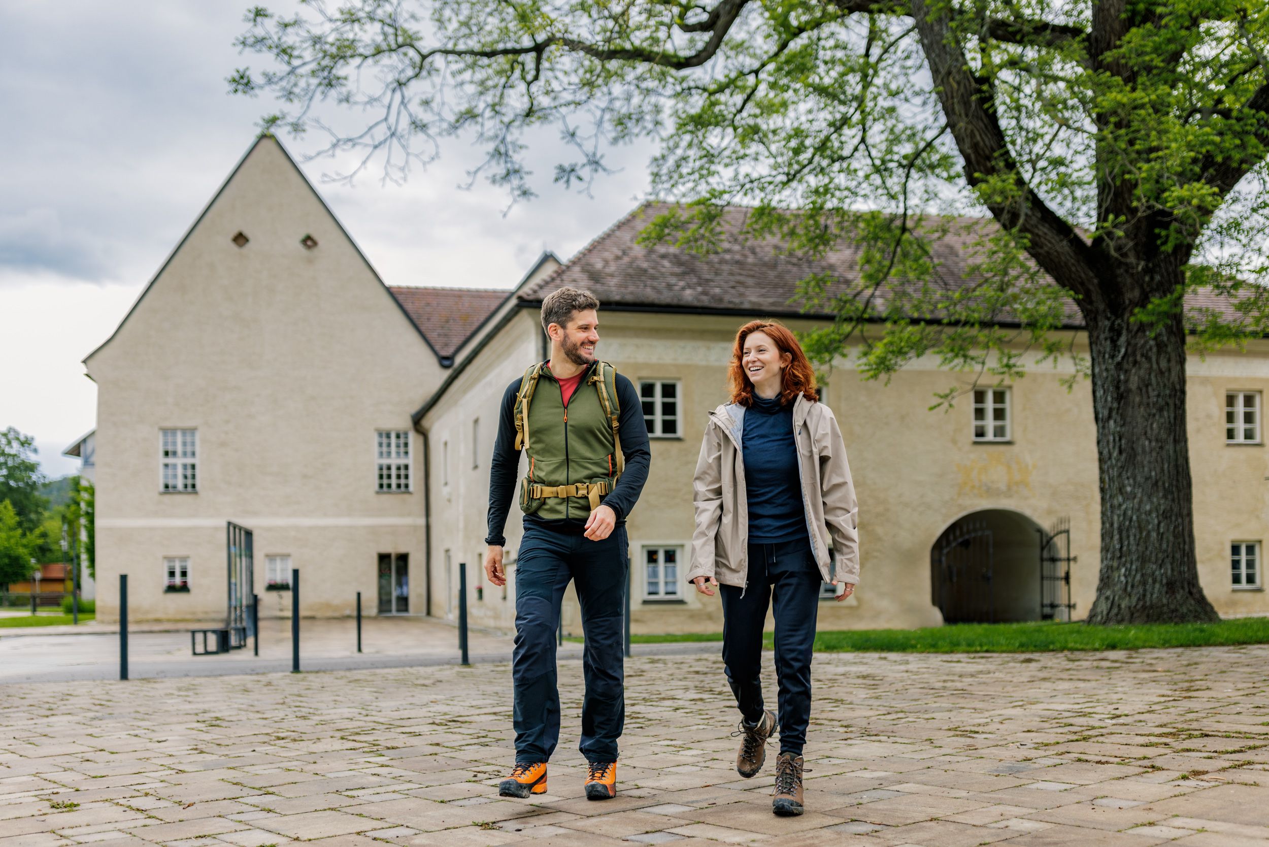 A man and a woman in hiking clothes in front of Katzelsdorf Castle