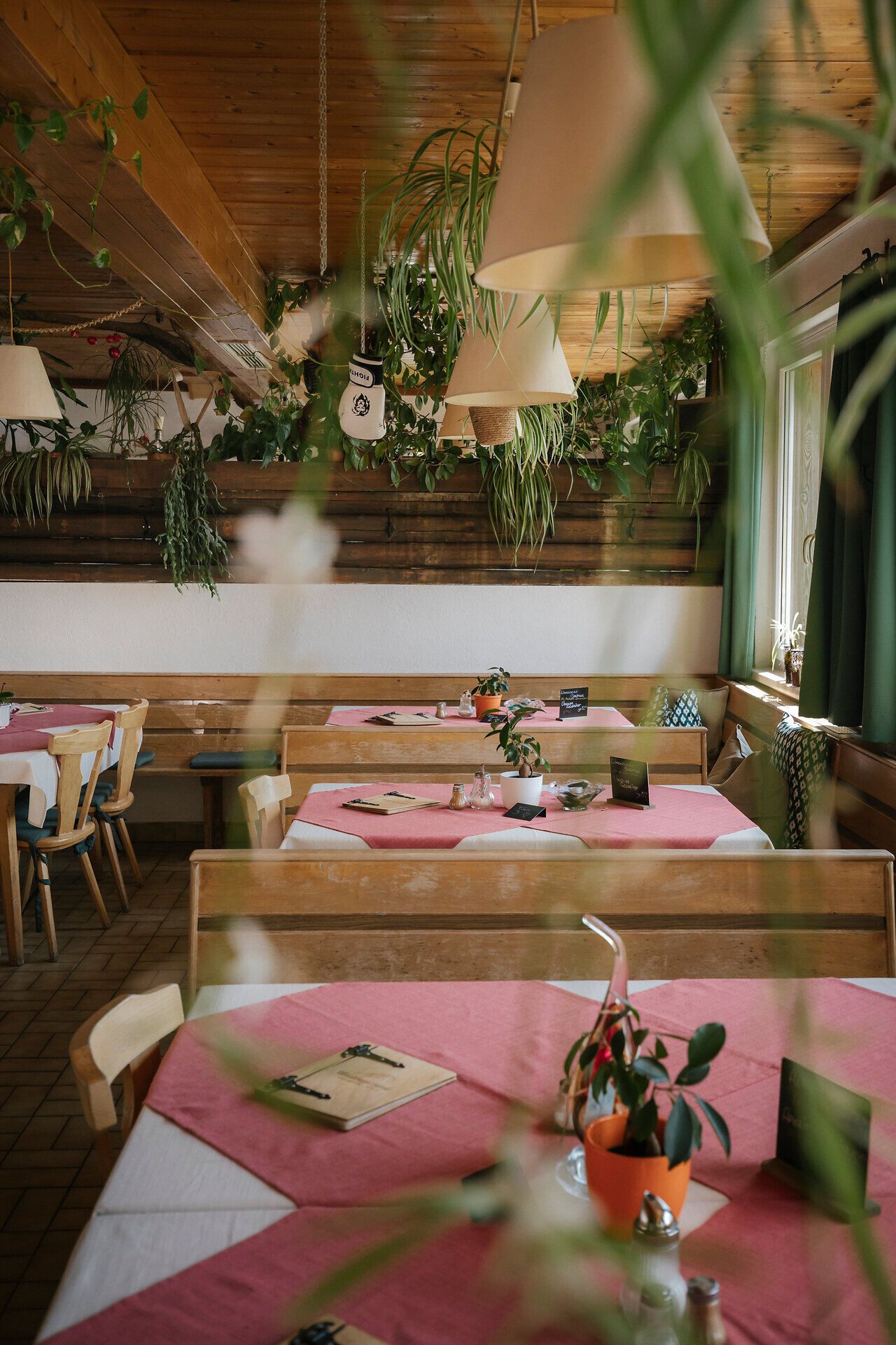 The cozy dining room at the Waxriegelhaus on the Rax, with set tables, plants, and lots of wood