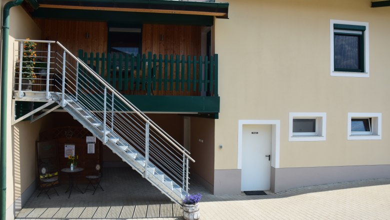 Exterior view of a building with stairs and balcony.