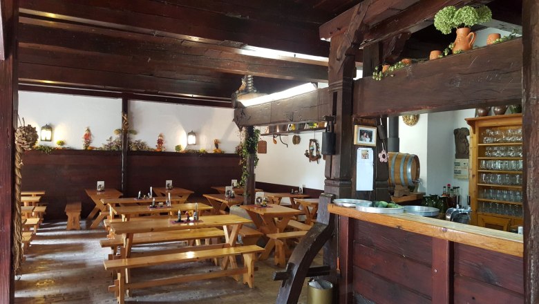 Interior view of a rustic wine tavern with wooden tables and decorations.
