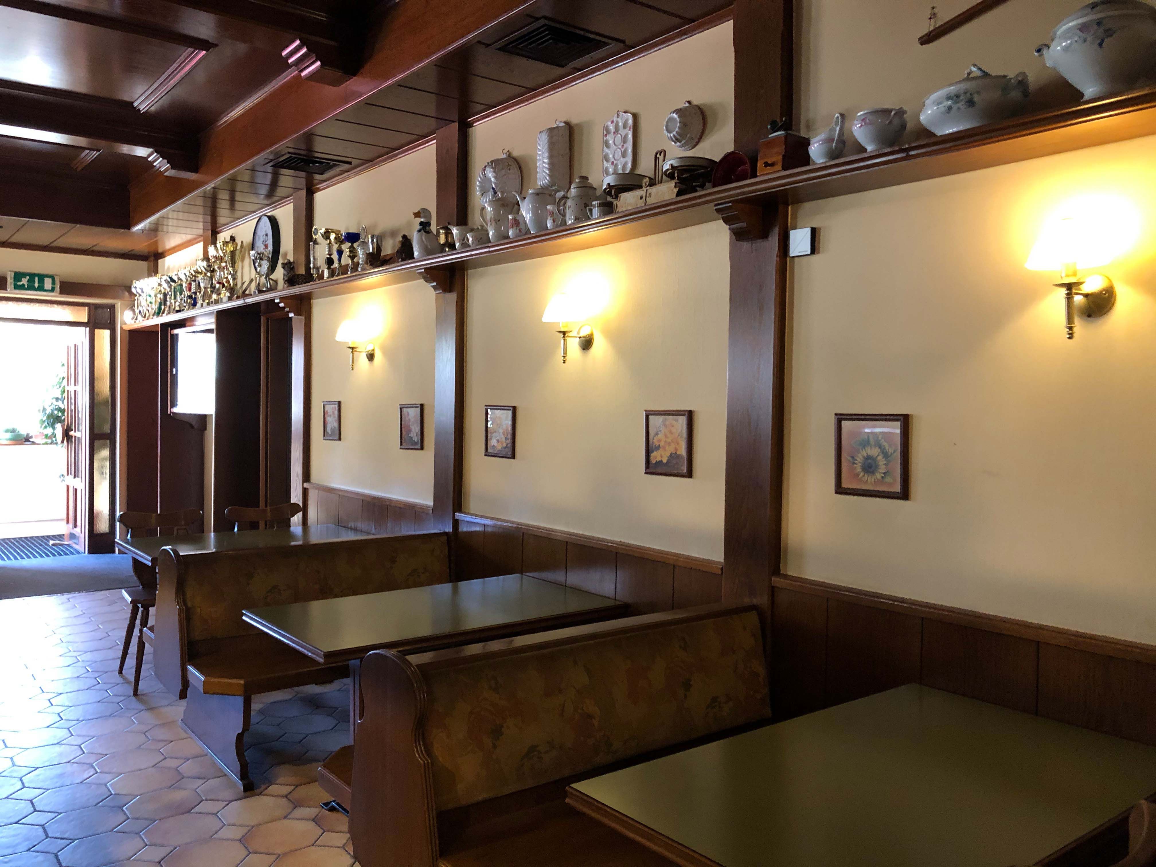 Interior view of a traditional inn with wooden furniture and decorations on a shelf.