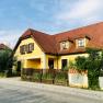 Yellow country house with red tiled roof and garden.