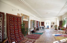 A room in Gro&szlig; Siegharts Castle with colorful carpets on the walls and floor.
