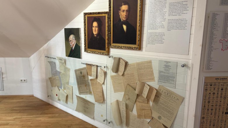 Exhibition in the Sugar Museum with portraits and historical documents on the wall.