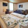 Comfortable guest room with double bed, sofa, desk and TV.