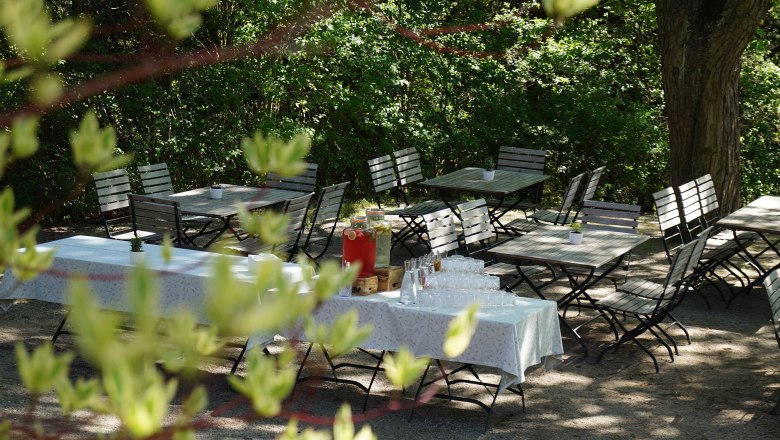 Elegant function room with a long, festively laid table and white chairs.