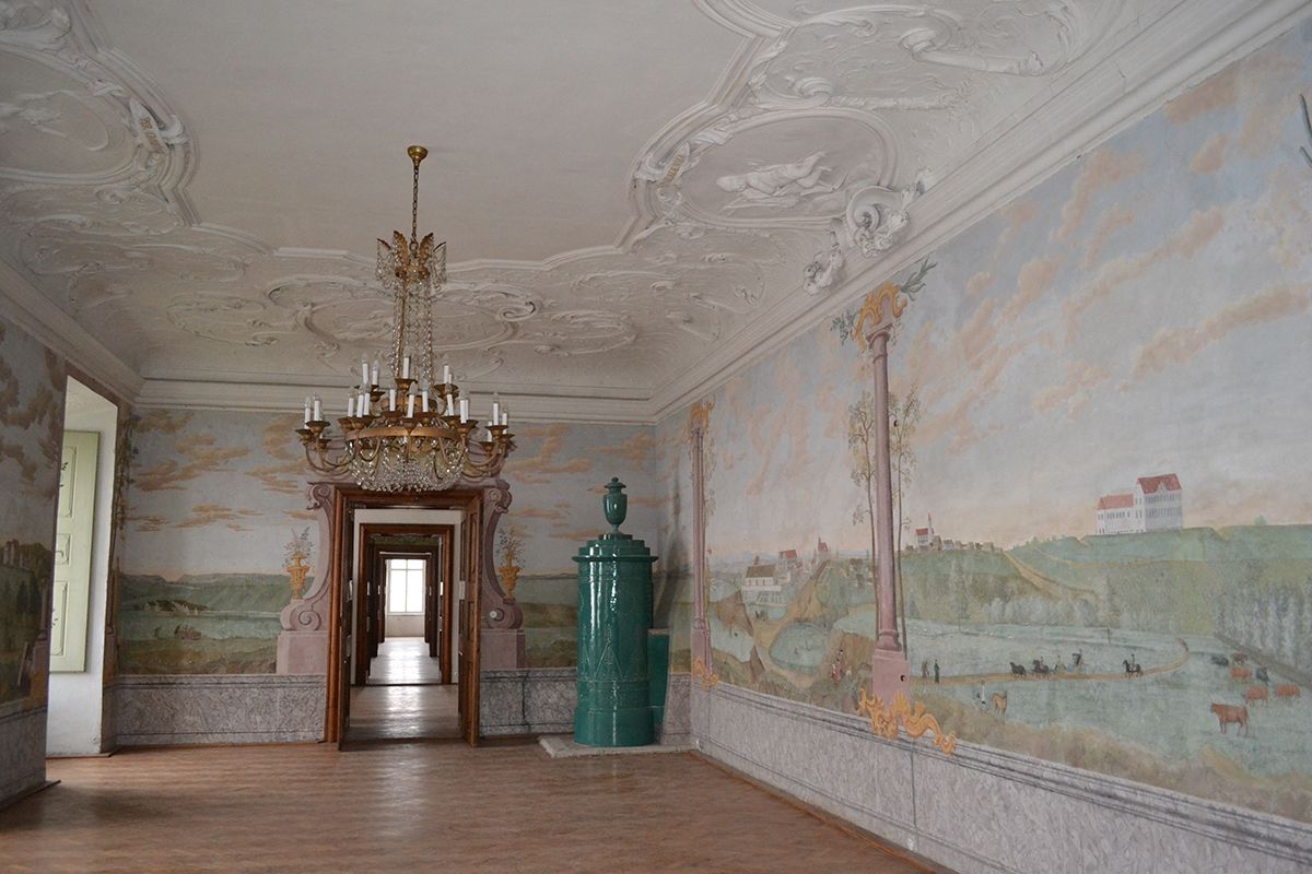 Elegant room in Stetteldorf Castle with wall paintings and a chandelier.