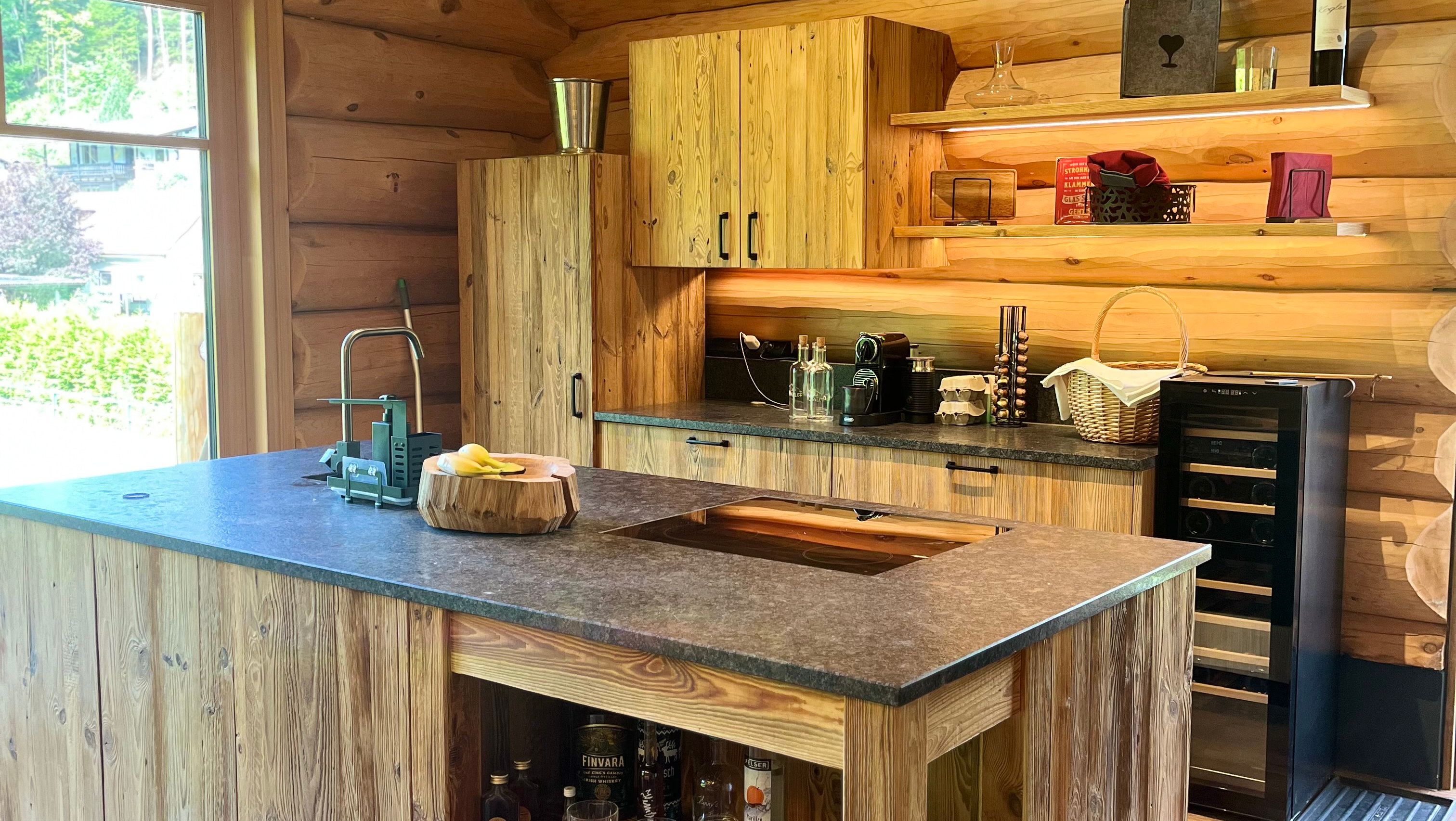Rustic wooden kitchen with modern equipment and view to the outside.