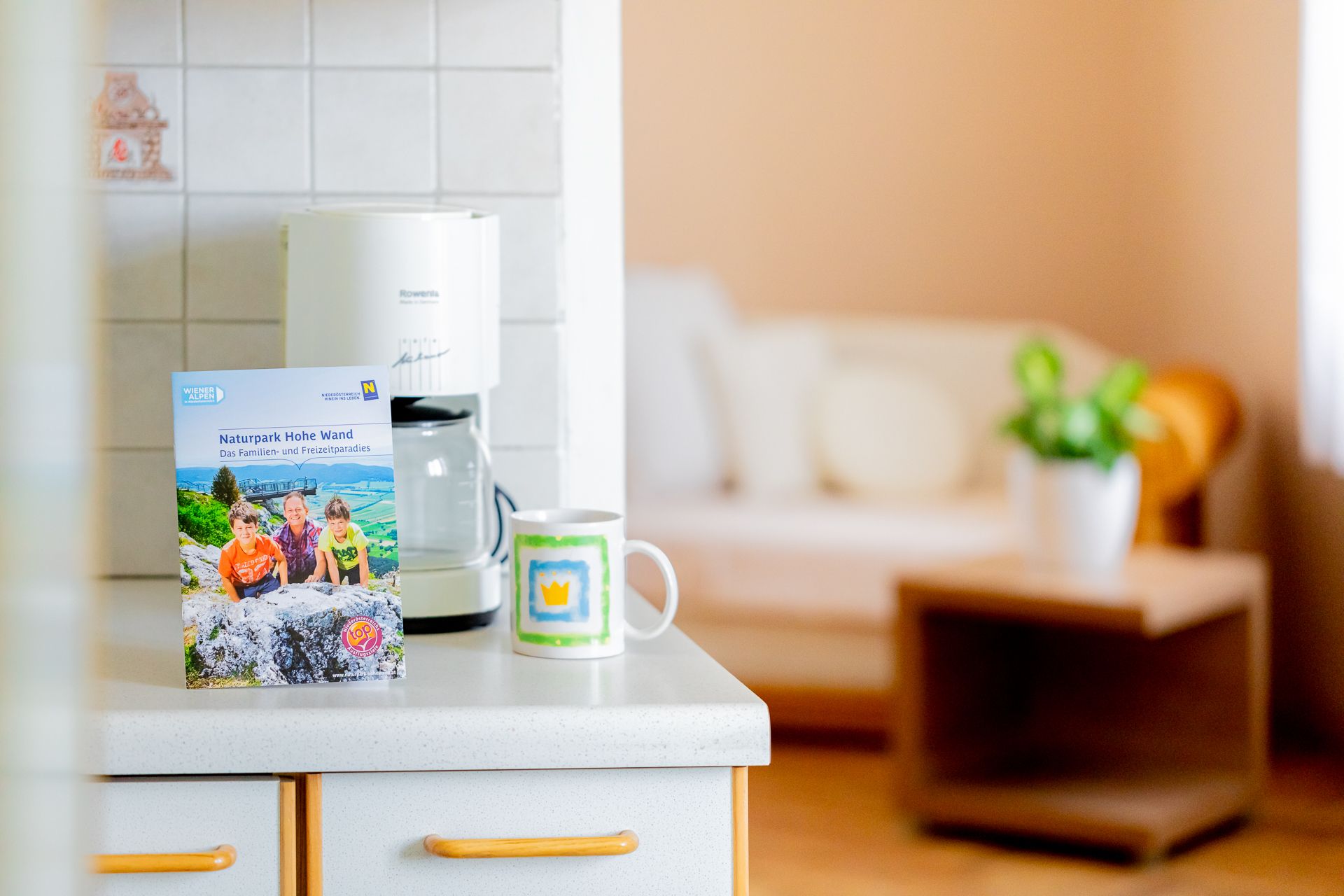 Kitchen worktop with brochure, coffee cup and coffee machine.
