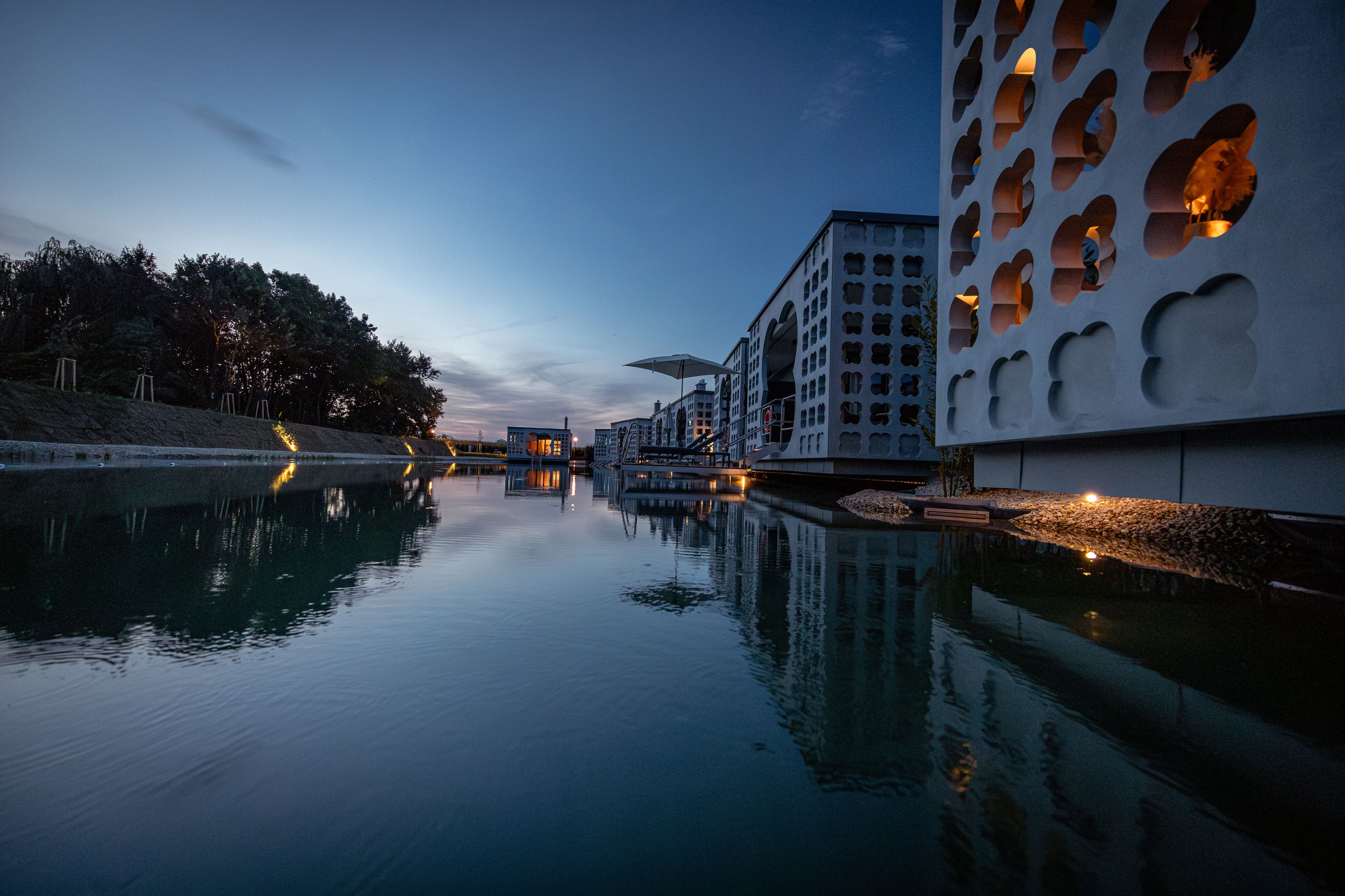Modern buildings with water reflections at dusk.