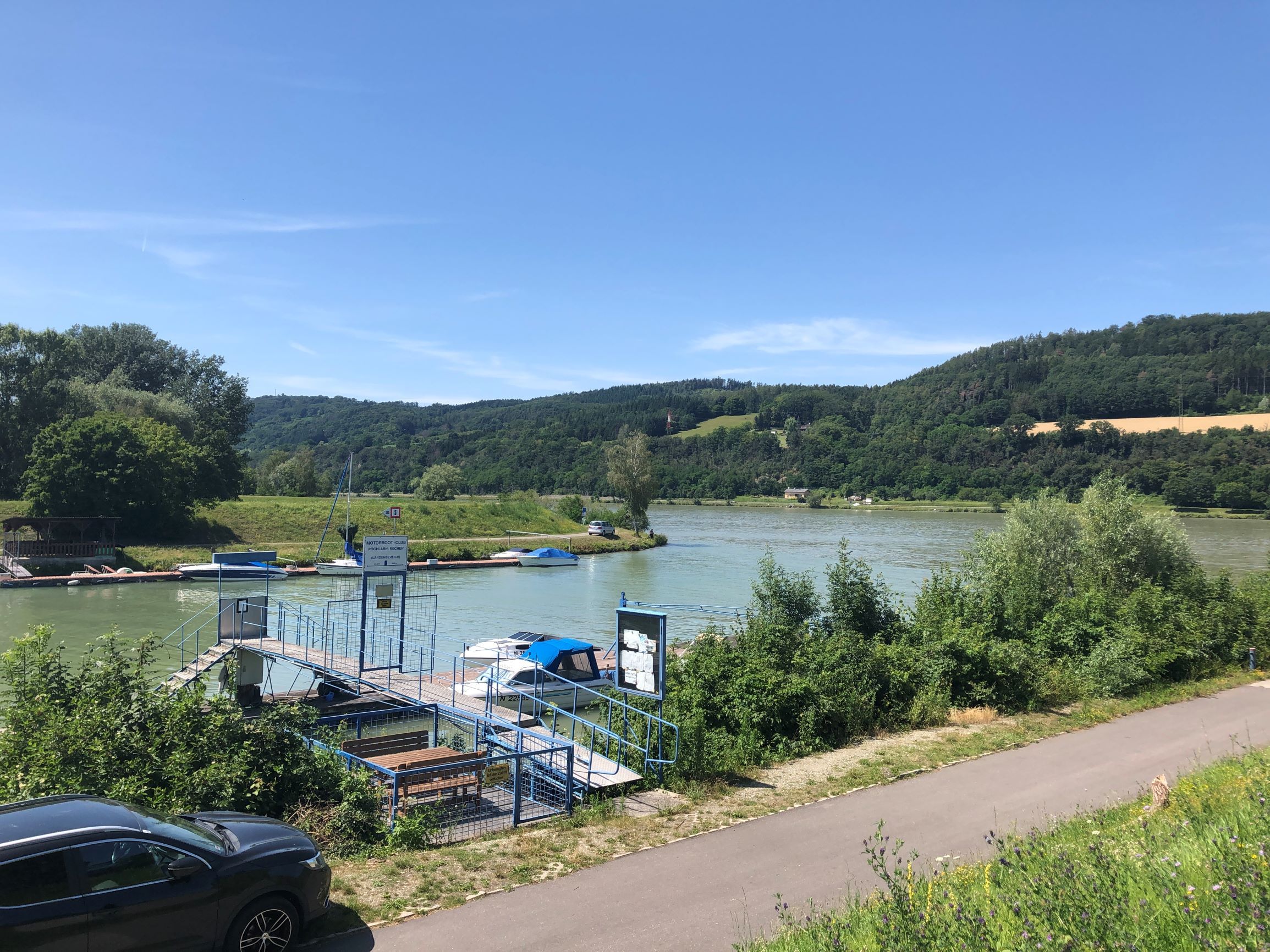 Mooring on the river with boats and green landscape in the background.