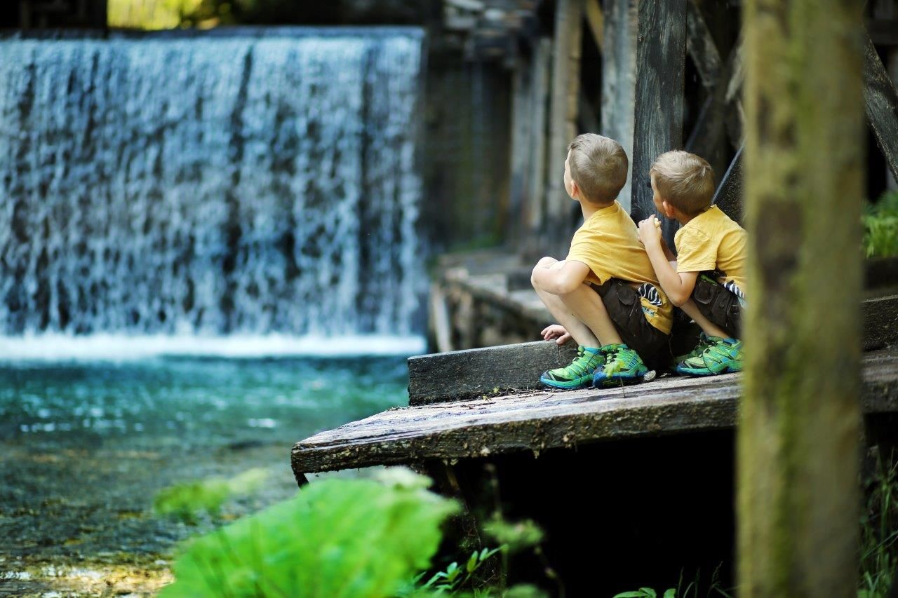 Two boys watch the falling water.