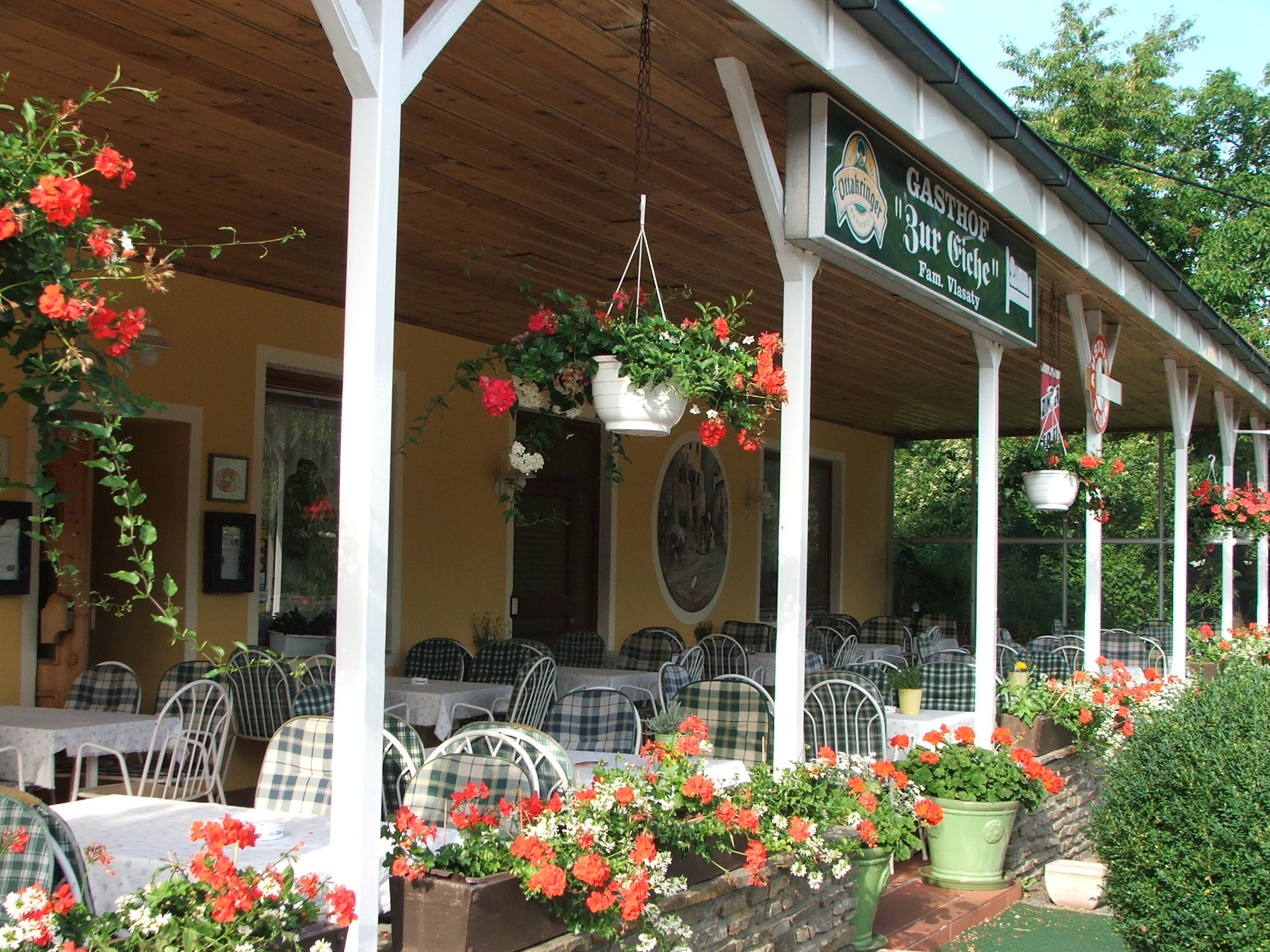Outdoor area of an inn with tables and flowers.