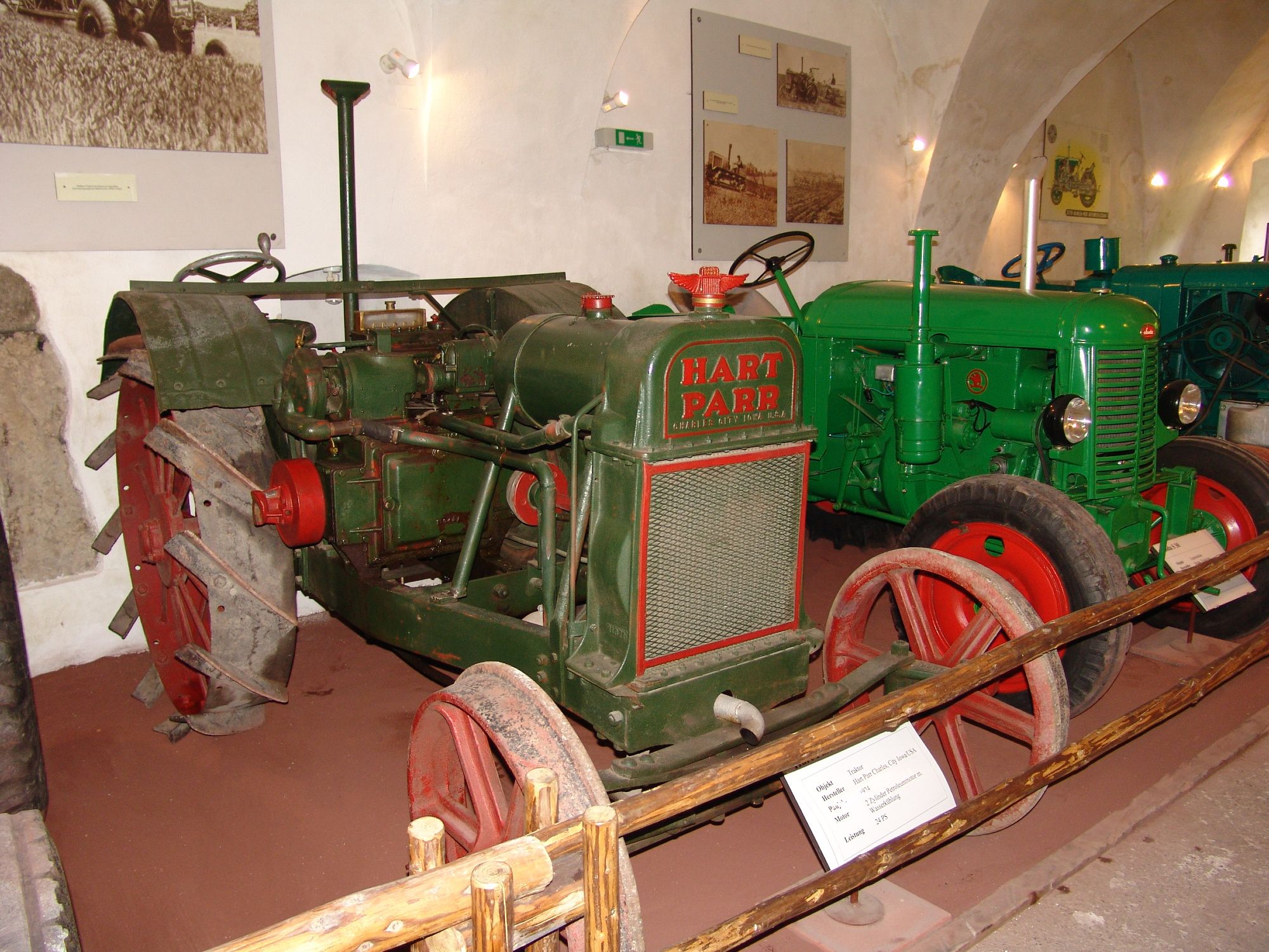 Old tractors on display in a museum.