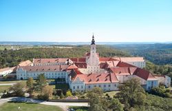 Aerial view of Altenburg Abbey in the middle of a green landscape.