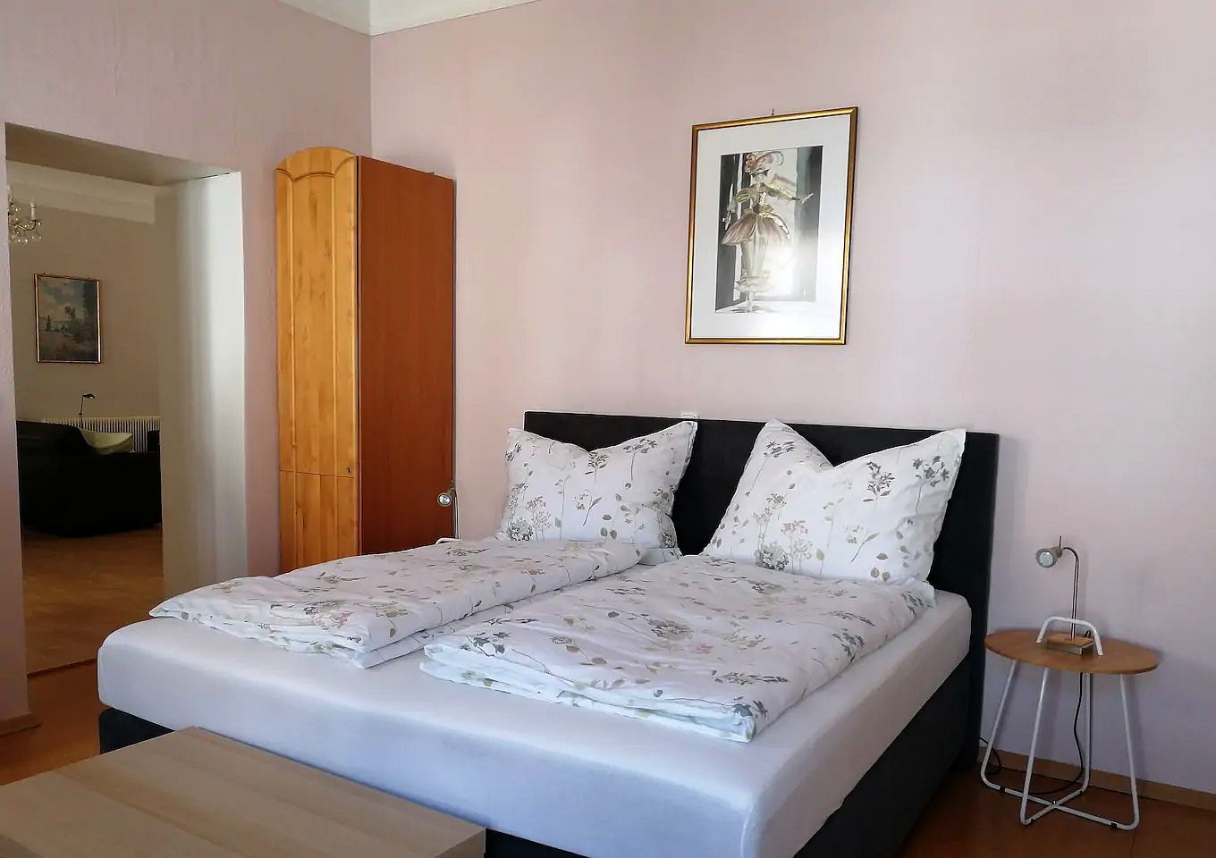 Bedroom with double bed, wooden wardrobe and mural.