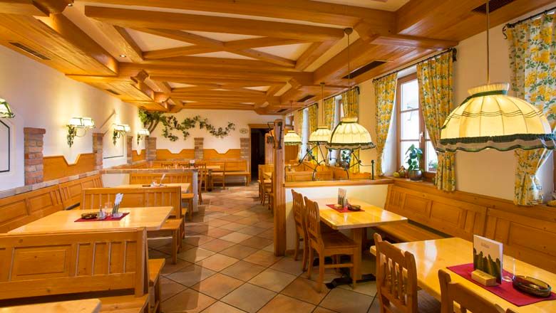 Interior view of a traditional wine tavern with wooden furniture and cozy lighting.