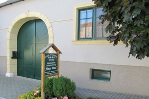 Entrance to a guest house with green gate and sign "Haus Resi".