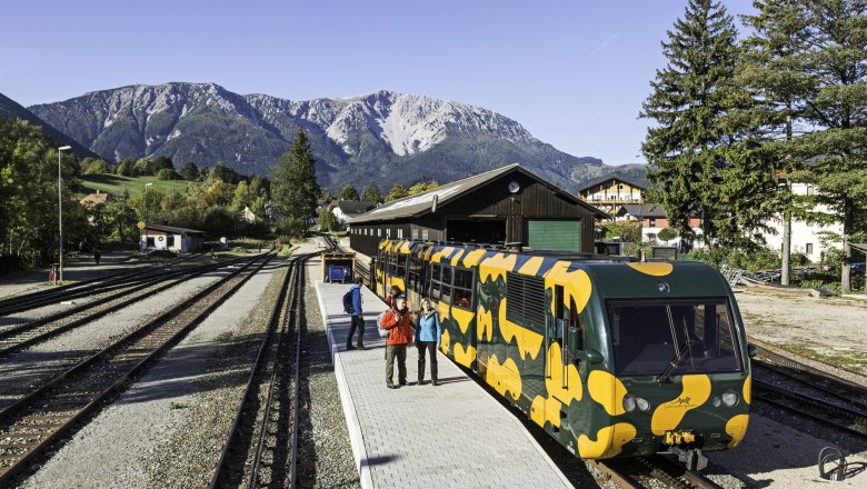 Railroad station in Puchberg am Schneeberg with a colorful rack railroad in the foreground and mountains in the background.