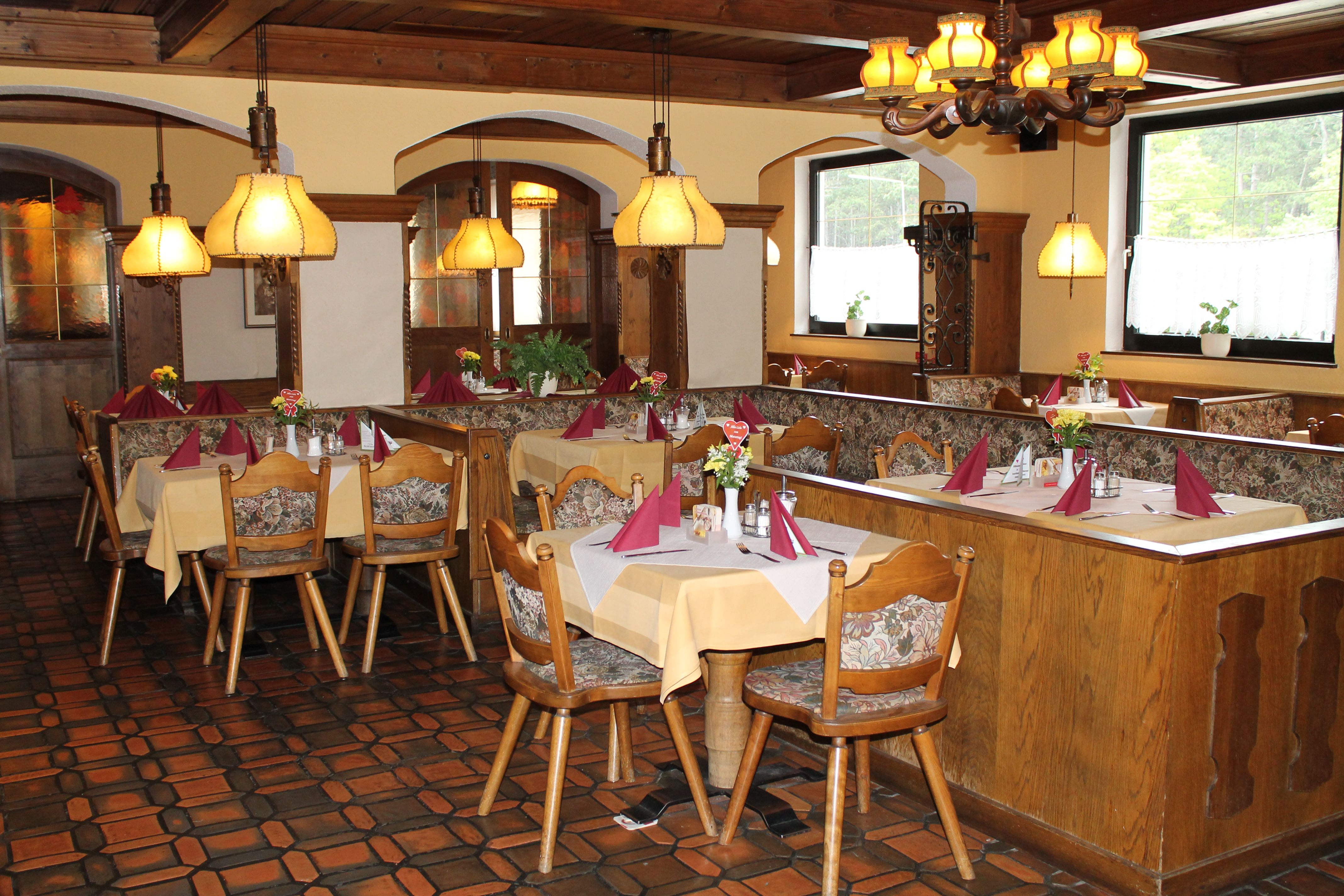 Cozy restaurant with wooden furniture and laid tables.